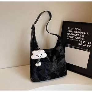 Detail of velvet shoulder bag with cloud texture and white plush smiley face charm