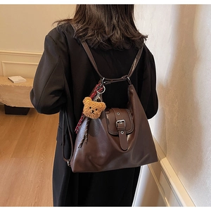 Detailansicht der Vintage-Tragetasche mit Leder-Schnalle und Plüschbär-Anhänger