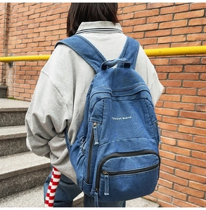 Detalle de mochila de mezclilla azul con bordado blanco 7street Glane en el frente