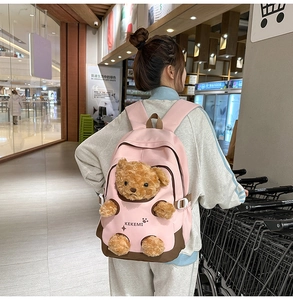 Detail of pink backpack featuring creative plush bear limbs popping through holes