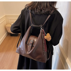 Detailansicht der dunkelbraunen Retro-Tasche als Rucksack mit Bärenanhänger getragen