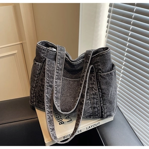 Détail du grand sac cabas en denim noir avec poches latérales et coutures apparentes