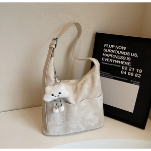 Close-up of beige marble pattern tote bag featuring a cute plush cloud charm