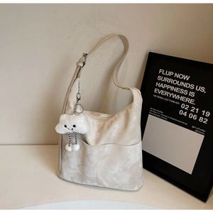 Detail of hobo bag with marble pattern, adjustable strap and cute cloud charm pendant