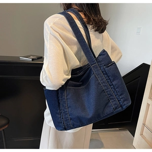 Vue détaillée du grand sac cabas en denim bleu foncé avec coutures et poche latérale