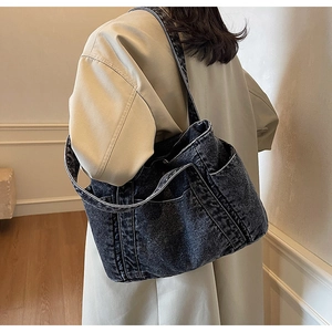 Vue latérale du grand sac cabas en denim avec surpiqûres et poches extérieures