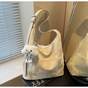 Detail of minimalist tote bag with marble pattern, adjustable strap and cloud pendant