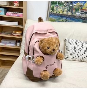 Detail showing pink backpack with cute plush bear limbs protruding from openings