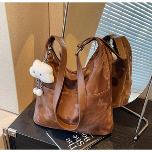 Detailed shot of brown vintage tote bag with marble texture and plush cloud charm