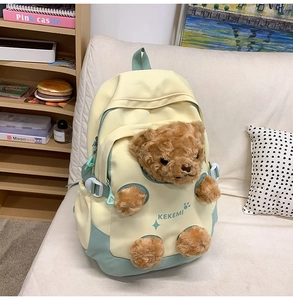 Detail of the cute teddy bear plush 3D pocket on a green and yellow student backpack