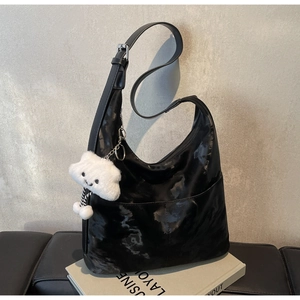 Detail of black large capacity hobo bag with marble texture and white cloud charm