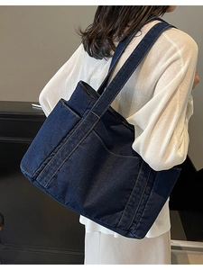 Sac fourre-tout en denim bleu foncé avec surpiqûres contrastées et grande capacité, vue latérale