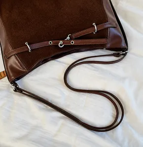 Detail of the stitching and metal ring attachment on the brown vintage tote bag strap