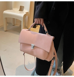 Detail of pink matte briefcase bag with silver square buckle and reinforced top handle