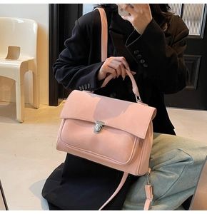 Detailed texture of pink matte crossbody bag featuring silver metal lock and handle
