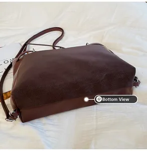 Detailed bottom view of large dark brown tote bag showing smooth and embossed leather