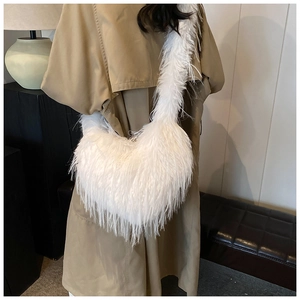 Close-up of white faux fur crossbody bag detail with fluffy feather texture on beige coat