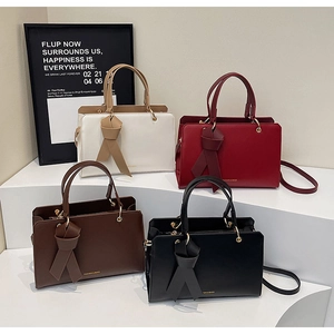 Detailansicht von vier Trapez-Handtaschen mit Metallgriffen und Schleifendekor
