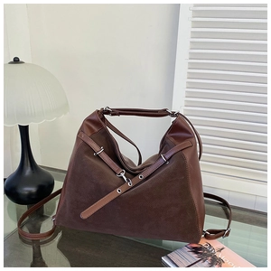 Detail of dark brown tote bag showing mixed textures of suede and smooth leather finishes