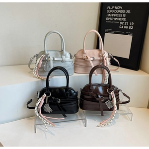 Collection of minimalist shell-style handbags in four colors with tennis racket charms