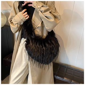 Detail of a black fluffy faux fur shoulder bag with long fibers and half-moon shape