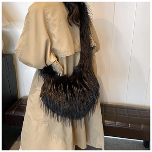 Close-up of black faux fur crossbody crescent bag worn with a beige trench coat