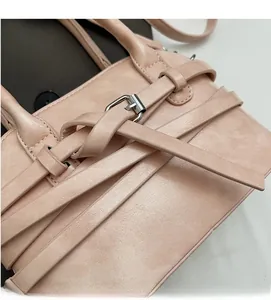 Close-up of pink PU leather texture with decorative cross straps and silver buckle
