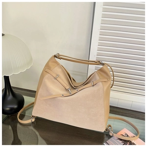 Detail of light brown hobo bag featuring mixed materials and adjustable leather strap