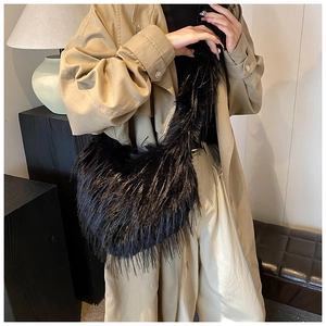 Close-up of black faux fur texture on a plush hobo crossbody bag for winter fashion