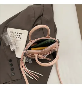 Pink shell handbag showing spacious interior with phone and wallet inside