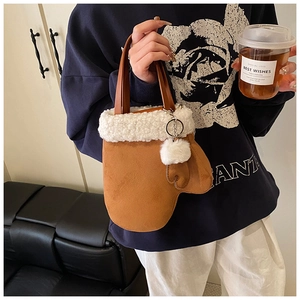 Detailansicht der braunen Tasche in Handschuhform mit Kunstlammfell und flauschigem Pompon