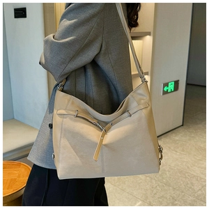 Close-up of beige lychee texture leather tote bag with stylish drawstring detail