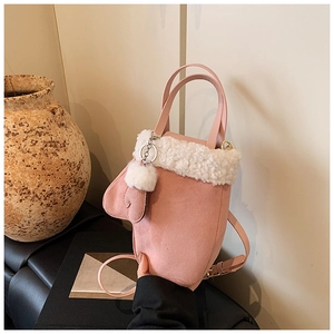 Rosa Wildleder-Handtasche mit weißem Kunstpelzbesatz und süßem Handschuh-Anhänger im Detail