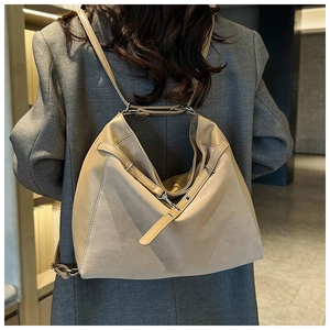 Detail of beige multi-way tote bag showing soft leather texture and adjustable strap