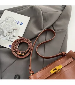 Detail of vintage brown leather handbag with gold twist lock and smooth dual straps