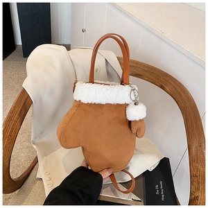 Detail einer handschuhförmigen Wildledertasche mit weißem Kunstfellbesatz und Pompon