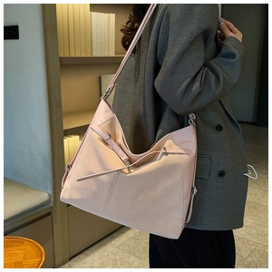 Detailed view of a pink textured faux leather hobo bag with adjustable strap and silver buckles