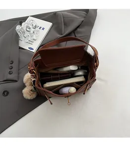 Top-down view of a vintage brown leather bag showing spacious interior with personal items
