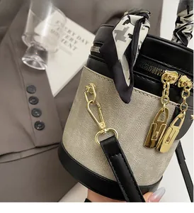 Detail of a vintage contrast bucket bag with gold hardware and houndstooth scarf handle
