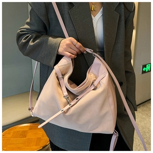 Detail of the light pink bucket bag with silver metal buckles and fine leather texture