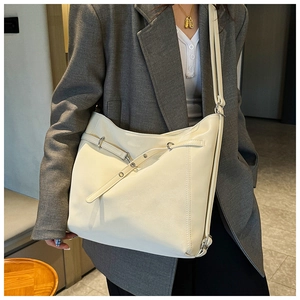 Detail view of large cream tote bag with elegant silver buckle and leather straps
