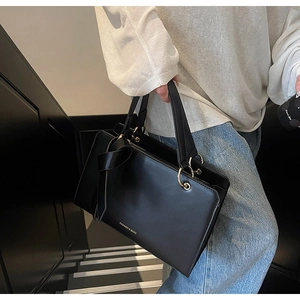 Detail einer schwarzen Leder-Shopper-Tasche mit dekorativer Schleife und Gold-Hardware