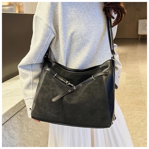 Close-up of black commuter tote bag featuring matte textures and silver metal hardware