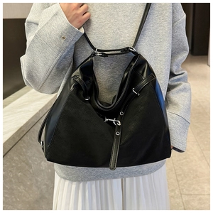 Detail of vintage black tote bag with silver metallic buckle and mixed leather textures