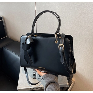 Detailansicht schwarze Shopper Tasche mit goldenen Ringen und dekorativem Lederknoten