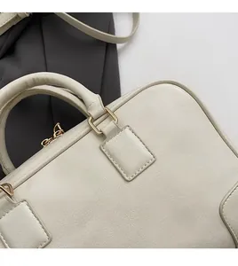 Detailed close-up showing the soft textured leather and gold metal buckle of the Boston bag