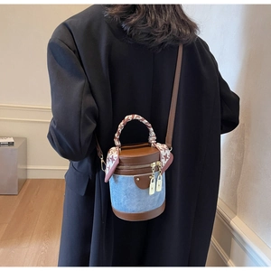 Detail of vintage patchwork bucket bag with denim fabric and scarf-wrapped handle