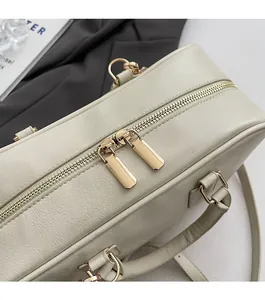 Detailed close-up of smooth dual golden zippers and pebble leather texture of Boston bag