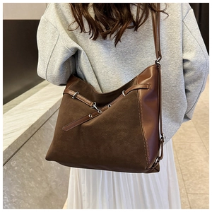 Detail of dark brown tote bag showing contrast stitching and premium matte leather texture
