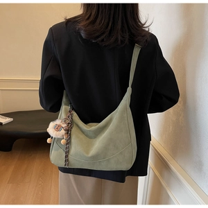 Detailed back view of large sage green suede hobo bag with cute sheep charm accessory